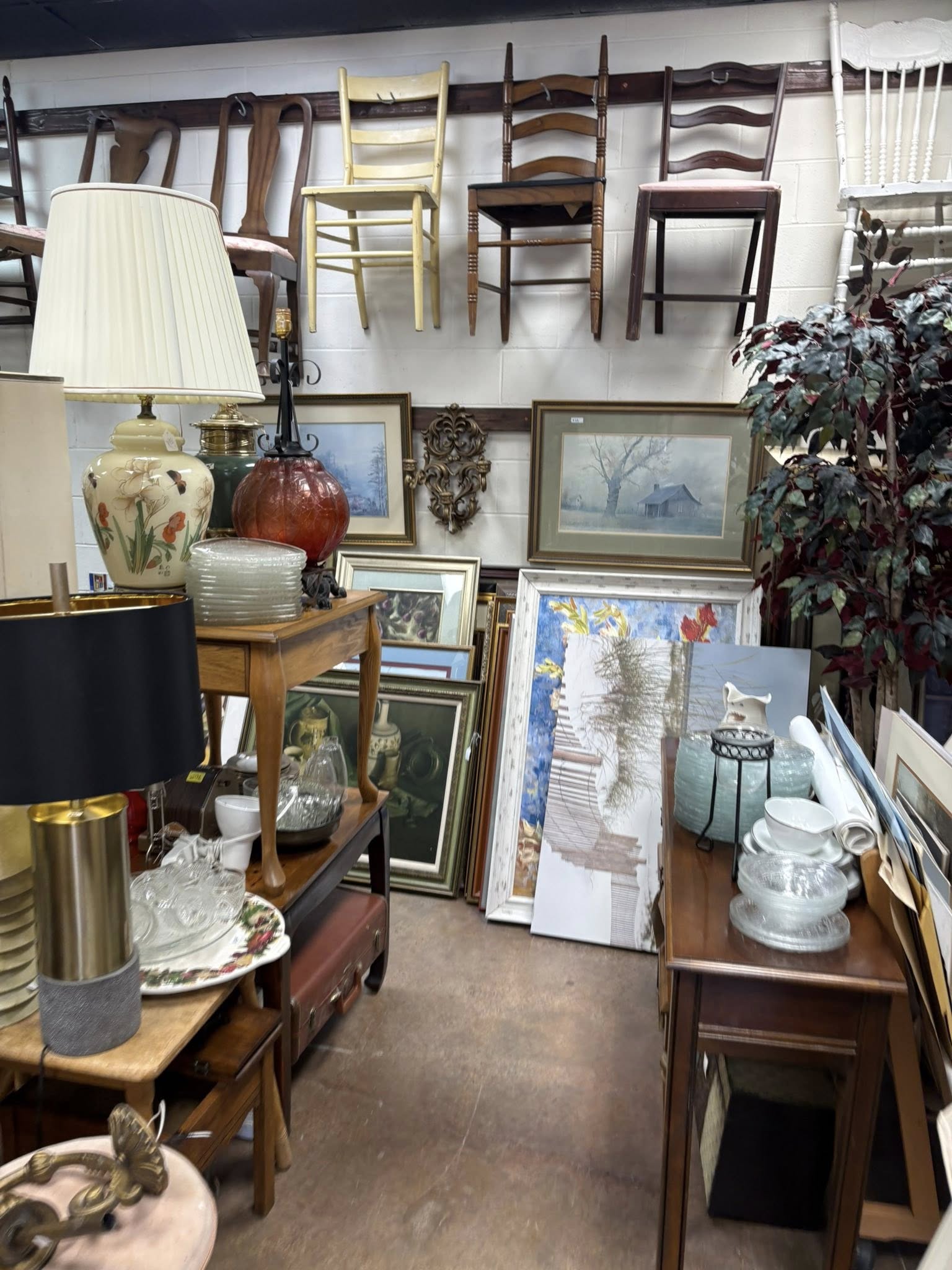 Framed art, lamps, and chairs arranged inside Vintiques
